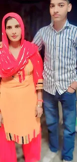 Portrait of two individuals in vibrant traditional attire.