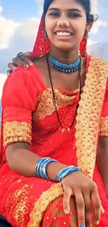 Woman in vibrant traditional red attire with intricate design.