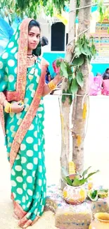 Woman in vibrant green saree performing a traditional ceremony outdoors.