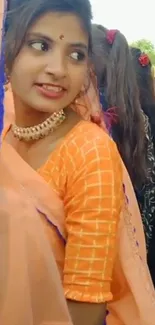 Woman in vibrant orange traditional attire.