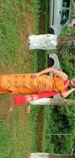 Woman in vibrant traditional saree amidst lush greenery.