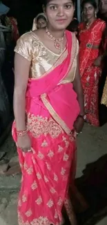 Elegant lady in vibrant pink traditional attire posing confidently.