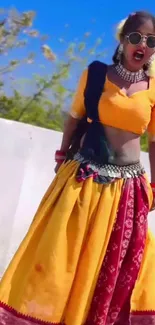 Vibrant female in traditional yellow and red attire, outdoors with stylish accessories.