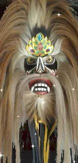 Colorful traditional mask with intricate design on a dark background.