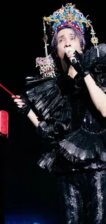 Traditional performer in ornate costume holding a red lantern against a dark background.