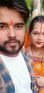 Vibrant portrait of a couple in traditional Indian attire with colorful background.