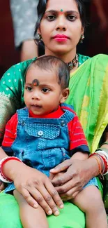 Mother and baby in colorful traditional attire with green and red hues.