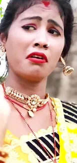 Woman in vibrant traditional attire with expressive face and jewelry.