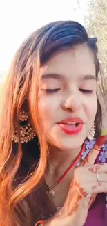 Woman in traditional attire with jewelry outdoors.