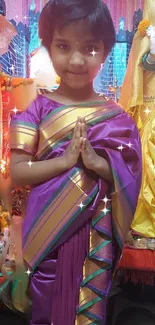 Child in traditional saree with colorful decor and sparkling accents.