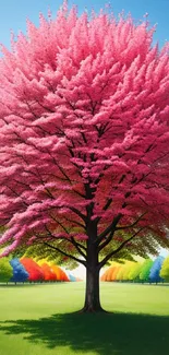 Vibrant pink tree against a colorful backdrop of trees and blue sky.