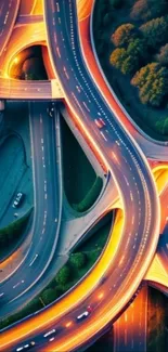 Aerial view of urban highway interchange glowing with city lights at night.