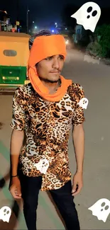 Person in leopard print shirt and orange scarf at night street.