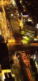 Aerial view of vibrant city streets illuminated at night.