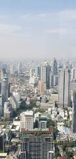 Aerial view of a vibrant urban skyline with river backdrop on a clear day.