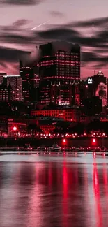 Vibrant skyline with red cityscape at night and reflective water.