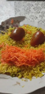 Smiley face made with rice, carrots, and tomatoes on a plate.