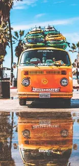 Orange van with surfboards on a sunny beach with palm trees.