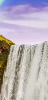 Beautiful waterfall with rainbow backdrop on a sunny day.