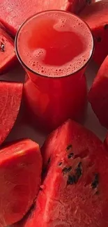 Vibrant watermelon slices around glass of juice.