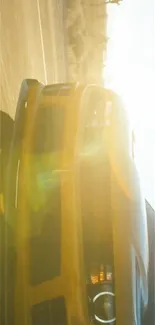 Yellow car in motion under bright sunlight.