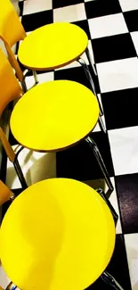 Vibrant yellow chairs on a black and white checkered floor.