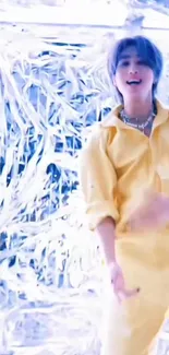 Person in yellow outfit dancing with a shiny silver background.