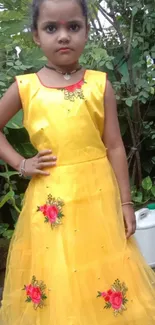 Young girl in a vibrant yellow dress with floral embroidery.