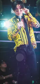 Person on stage in vibrant yellow outfit with microphone.