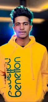 Man in a bright yellow hoodie with vibrant background.