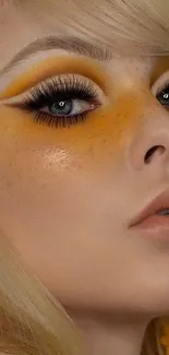 Close-up of a face with vibrant yellow makeup and flower earrings.