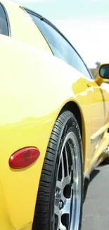 Bright yellow sports car parked on a road, capturing a dynamic angle.