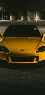 Vibrant yellow sports car parked at night.