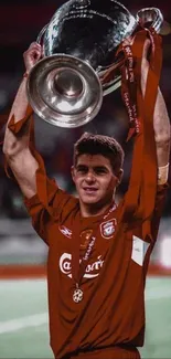 Soccer player joyfully holding trophy on field.