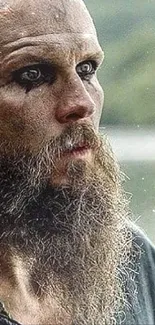 Intense Viking with braided beard by lake.