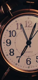 Vintage alarm clock with bronze finish and classic numeral design.