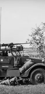 Black and white vintage battlefield scene wallpaper with soldiers and vehicle.