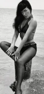 Vintage black and white beach portrait of a woman in swimwear on a seaside setting.