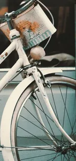 A vintage white bicycle against a teal background, evoking nostalgia and charm.