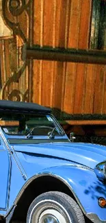 Vintage blue car in front of wooden house.