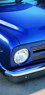 Vintage blue car with chrome details and round headlight.