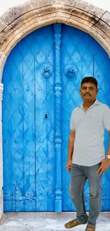 Mobile wallpaper with a vintage blue door and stone archway.