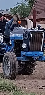 Vintage blue tractor parked in a rustic farm setting, showcasing countryside life.