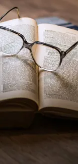 Open vintage book with glasses on wooden surface.