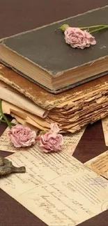 Vintage books with pink roses on a wooden table.