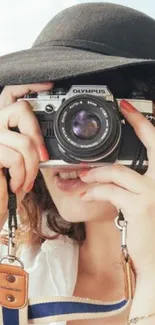 Woman with vintage camera and black hat.