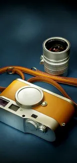 Vintage camera with lens and strap on dark teal background.