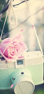 A pastel green vintage camera with a pink rose, ideal as a mobile wallpaper.