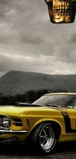 Vintage yellow car with metallic skull under stormy skies.