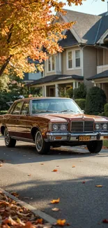 Vintage car on suburban street with autumn foliage.